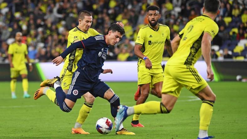 Oct 14, 2023; Nashville, Tennessee, USA; New England Revolution forward Tomas Chancalay (5) and Nashville SC midfielder Alex Muyl (19) battle for the ball during the first half at Geodis Park. Mandatory Credit: Christopher Hanewinckel-USA TODAY Sports