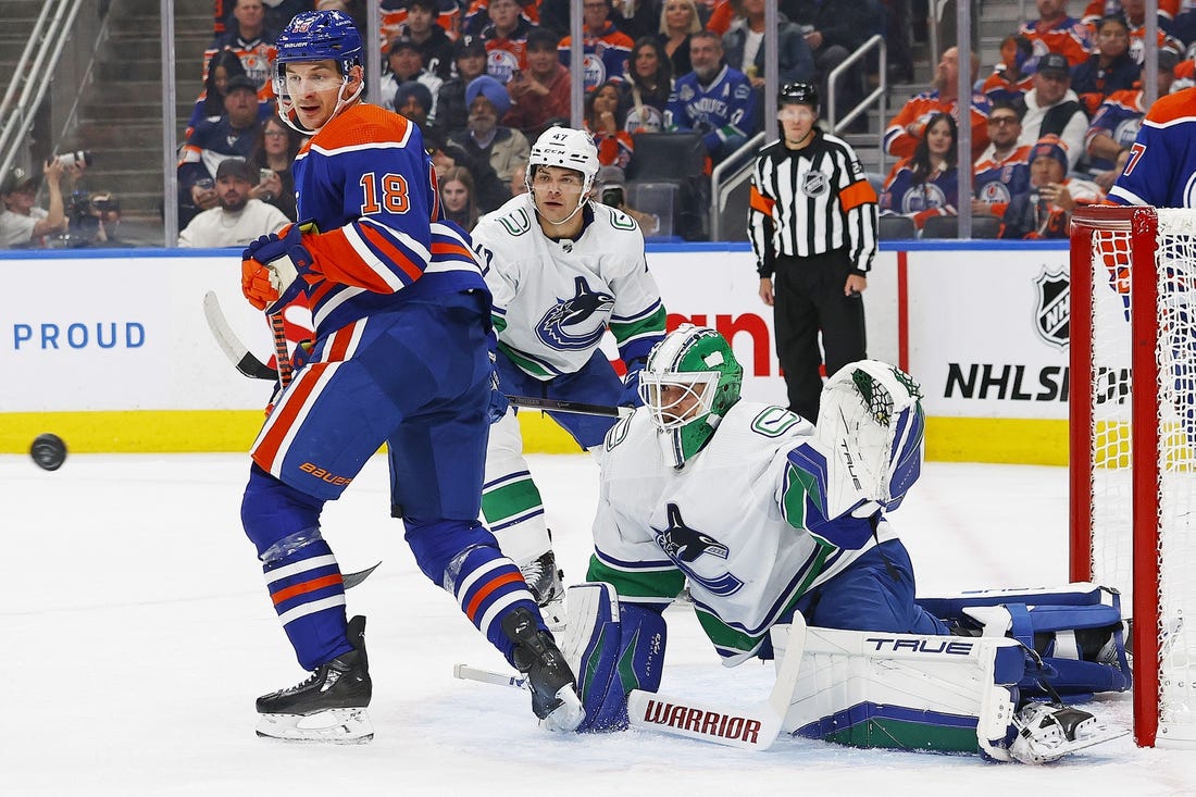 Oct 14, 2023; Edmonton, Alberta, CAN; Edmonton Oilers forward Zach Hyman (18) and Vancouver Canucks goaltender Casey DeSmith (29) look for a loose puck during the first period at Rogers Place. Mandatory Credit: Perry Nelson-USA TODAY Sports