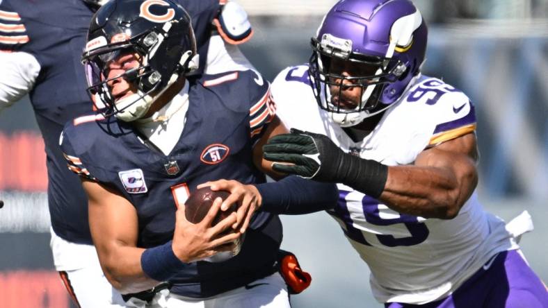 Oct 15, 2023; Chicago, Illinois, USA;  Chicago Bears quarterback Justin Fields (1) is chased out of the pocket by Minnesota Vikings linebacker Danielle Hunter (99) in the first half at Soldier Field. Mandatory Credit: Jamie Sabau-USA TODAY Sports