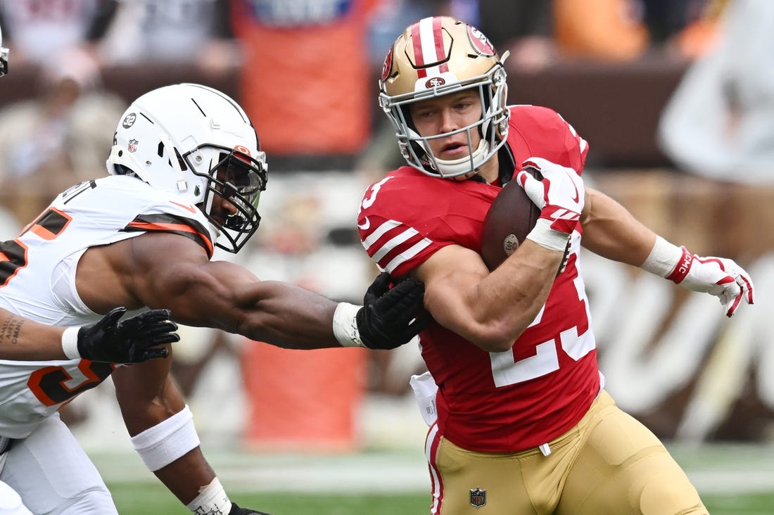 Oct 15, 2023; Cleveland, Ohio, USA; San Francisco 49ers running back Christian McCaffrey (23) runs from Cleveland Browns defensive end Myles Garrett (95) during the first half at Cleveland Browns Stadium. Mandatory Credit: Ken Blaze-USA TODAY Sports