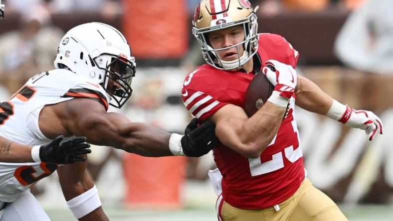 Oct 15, 2023; Cleveland, Ohio, USA; San Francisco 49ers running back Christian McCaffrey (23) runs from Cleveland Browns defensive end Myles Garrett (95) during the first half at Cleveland Browns Stadium. Mandatory Credit: Ken Blaze-USA TODAY Sports