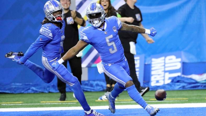 Lions receiver Jameson Williams celebrates with running back David Montgomery (5) after Montgomery's touchdown against the Panthers during the first half Sunday, Oct. 8, 2023, at Ford Field.