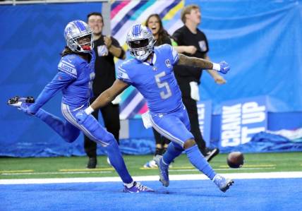 Lions receiver Jameson Williams celebrates with running back David Montgomery (5) after Montgomery's touchdown against the Panthers during the first half Sunday, Oct. 8, 2023, at Ford Field.