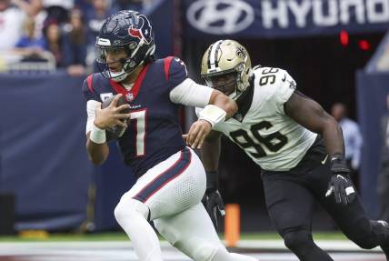 Oct 15, 2023; Houston, Texas, USA; Houston Texans quarterback C.J. Stroud (7) runs with the ball as New Orleans Saints defensive end Carl Granderson (96) defends during the first quarter at NRG Stadium. Mandatory Credit: Troy Taormina-USA TODAY Sports