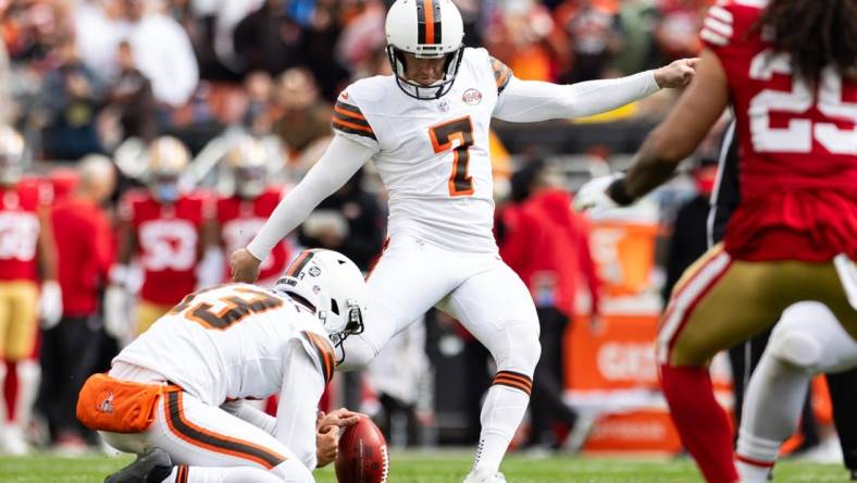 Oct 15, 2023; Cleveland, Ohio, USA; Cleveland Browns punter Corey Bojorquez (13) holds the ball for place kicker Dustin Hopkins (7) as he kicks a point after against the San Francisco 49ers during the second quarter try at Cleveland Browns Stadium. Mandatory Credit: Scott Galvin-USA TODAY Sports