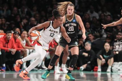 Oct 15, 2023; Brooklyn, New York, USA; Las Vegas Aces guard Chelsea Gray (12) drives around New York Liberty guard Sabrina Ionescu (20) in the third quarter during game three of the 2023 WNBA Finals at Barclays Center. Mandatory Credit: Wendell Cruz-USA TODAY Sports