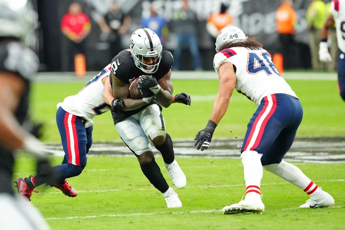 Oct 15, 2023; Paradise, Nevada, USA; Las Vegas Raiders running back Josh Jacobs (8) breaks through a hole against the New England Patriots during the first quarter at Allegiant Stadium. Mandatory Credit: Stephen R. Sylvanie-USA TODAY Sports