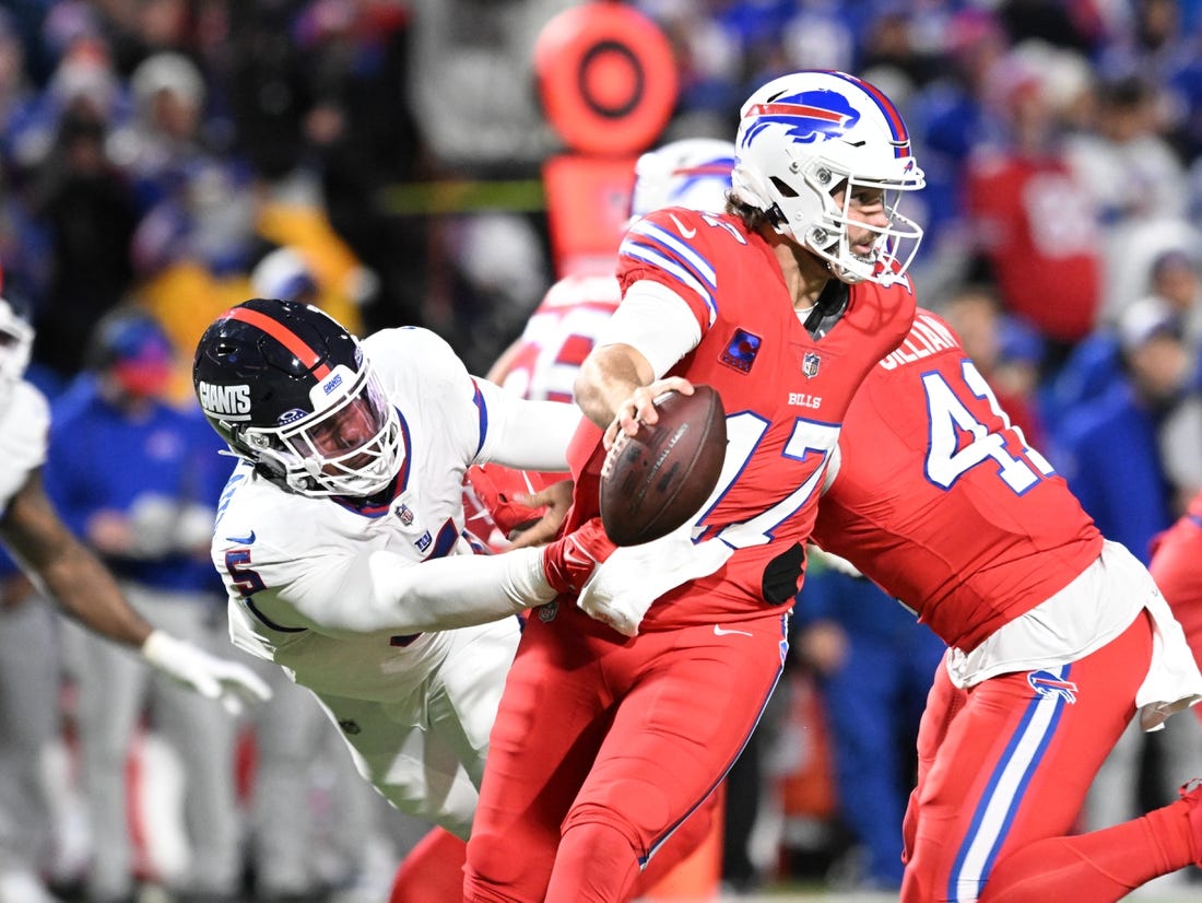 Oct 15, 2023; Orchard Park, New York, USA; Buffalo Bills quarterback Josh Allen (17) tries to avoid a tackle by New York Giants linebacker Kayvon Thibodeaux (5) in the third quarter at Highmark Stadium. Mandatory Credit: Mark Konezny-USA TODAY Sports