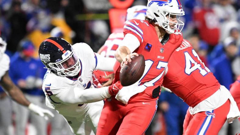 Oct 15, 2023; Orchard Park, New York, USA; Buffalo Bills quarterback Josh Allen (17) tries to avoid a tackle by New York Giants linebacker Kayvon Thibodeaux (5) in the third quarter at Highmark Stadium. Mandatory Credit: Mark Konezny-USA TODAY Sports