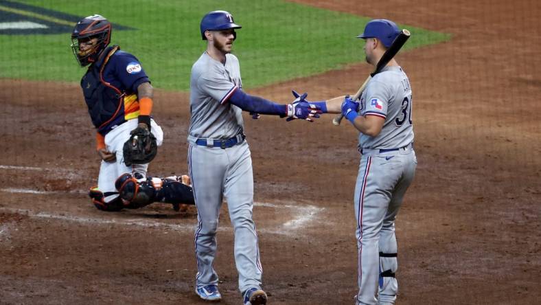 Oct 16, 2023; Houston, Texas, USA; Texas Rangers catcher Jonah Heim (28) celebrates with first baseman Nathaniel Lowe (30) after hitting a home run in the third inning against the Houston Astros during game two of the ALCS for the 2023 MLB playoffs at Minute Maid Park. Mandatory Credit: Troy Taormina-USA TODAY Sports