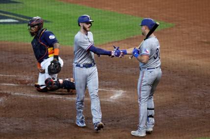 Oct 16, 2023; Houston, Texas, USA; Texas Rangers catcher Jonah Heim (28) celebrates with first baseman Nathaniel Lowe (30) after hitting a home run in the third inning against the Houston Astros during game two of the ALCS for the 2023 MLB playoffs at Minute Maid Park. Mandatory Credit: Troy Taormina-USA TODAY Sports