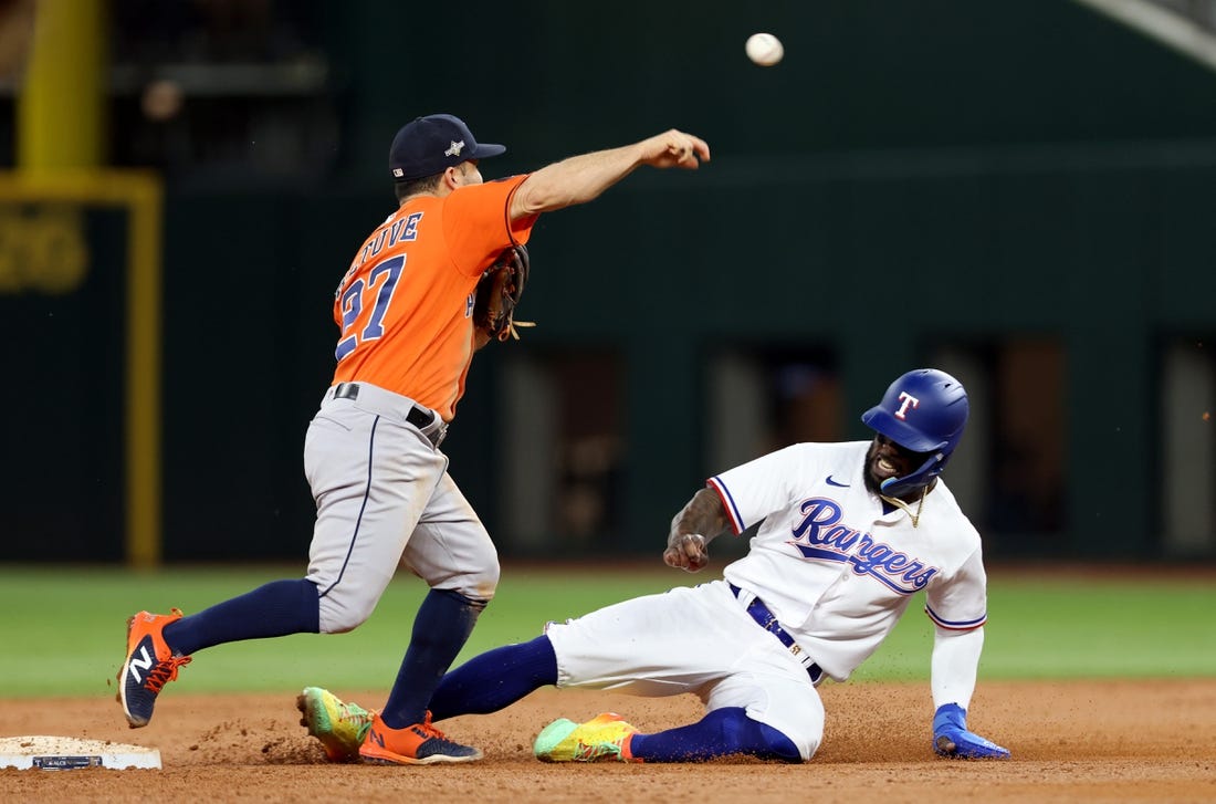 Oct 19, 2023; Arlington, Texas, USA; Houston Astros second baseman Jose Altuve (27) turns a double play against Texas Rangers right fielder Adolis Garcia (53) during the third inning in game four of the ALCS for the 2023 MLB playoffs at Globe Life Field. Mandatory Credit: Andrew Dieb-USA TODAY Sports