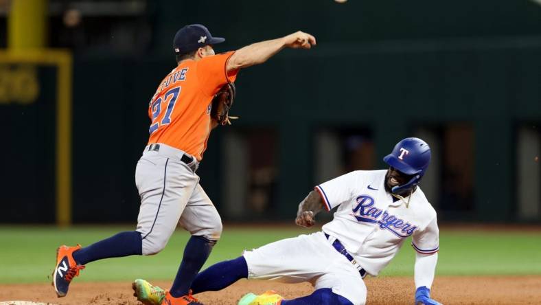 Oct 19, 2023; Arlington, Texas, USA; Houston Astros second baseman Jose Altuve (27) turns a double play against Texas Rangers right fielder Adolis Garcia (53) during the third inning in game four of the ALCS for the 2023 MLB playoffs at Globe Life Field. Mandatory Credit: Andrew Dieb-USA TODAY Sports