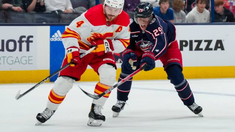 Oct 20, 2023; Columbus, Ohio, USA;  Calgary Flames defenseman Rasmus Andersson (4) skates with the puck against Columbus Blue Jackets right wing Patrik Laine (29) in the third period at Nationwide Arena. Mandatory Credit: Aaron Doster-USA TODAY Sports