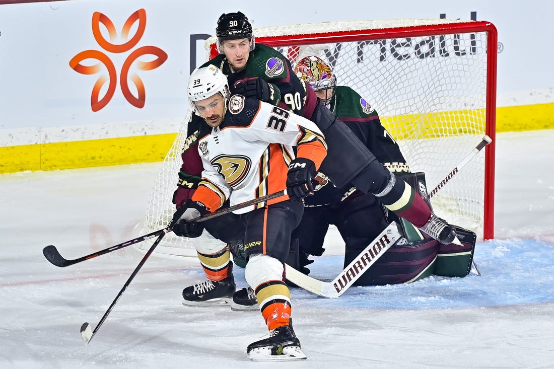 Oct 21, 2023; Tempe, Arizona, USA;  Anaheim Ducks center Sam Carrick (39) and Arizona Coyotes defenseman J.J. Moser (90) battle for position in front of goaltender Karel Vejmelka (70) in the first period at Mullett Arena. Mandatory Credit: Matt Kartozian-USA TODAY Sports