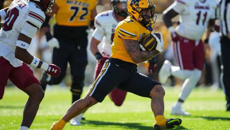 Oct 21, 2023; Columbia, Missouri, USA; Missouri Tigers running back Cody Schrader (7) runs the ball against South Carolina Gamecocks defensive back Judge Collier (20) during the first half at Faurot Field at Memorial Stadium. Mandatory Credit: Jay Biggerstaff-USA TODAY Sports