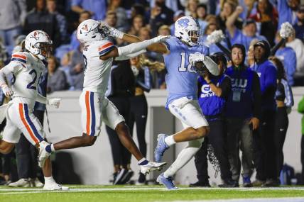 Oct 21, 2023; Chapel Hill, North Carolina, USA; North Carolina Tar Heels tight end Bryson Nesbit (18) scores a touchdown after a catch against Virginia Cavaliers safety Coen King (9) in the first half at Kenan Memorial Stadium. Mandatory Credit: Nell Redmond-USA TODAY Sports