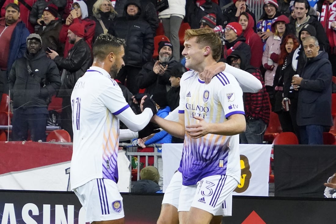 Oct 21, 2023; Toronto, Ontario, CAN; Orlando City SC midfielder Martin Ojeda (11) congratulates forward Duncan McGuire (13) on the first of his two goals against Toronto FC  during the second half at BMO Field. Mandatory Credit: John E. Sokolowski-USA TODAY Sports