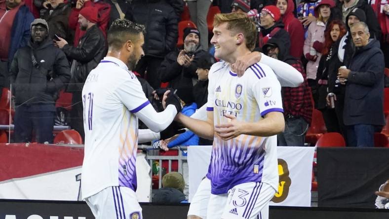 Oct 21, 2023; Toronto, Ontario, CAN; Orlando City SC midfielder Martin Ojeda (11) congratulates forward Duncan McGuire (13) on the first of his two goals against Toronto FC  during the second half at BMO Field. Mandatory Credit: John E. Sokolowski-USA TODAY Sports