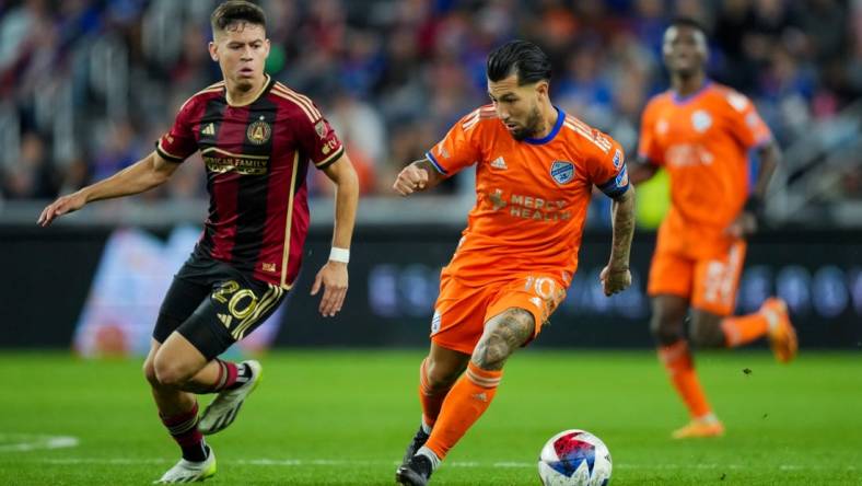 Oct 21, 2023; Cincinnati, Ohio, USA;  FC Cincinnati midfielder Luciano Acosta (10) dribbles the ball against Atlanta United FC midfielder Matheus Rossetto (20) in the second half at TQL Stadium. Mandatory Credit: Aaron Doster-USA TODAY Sports