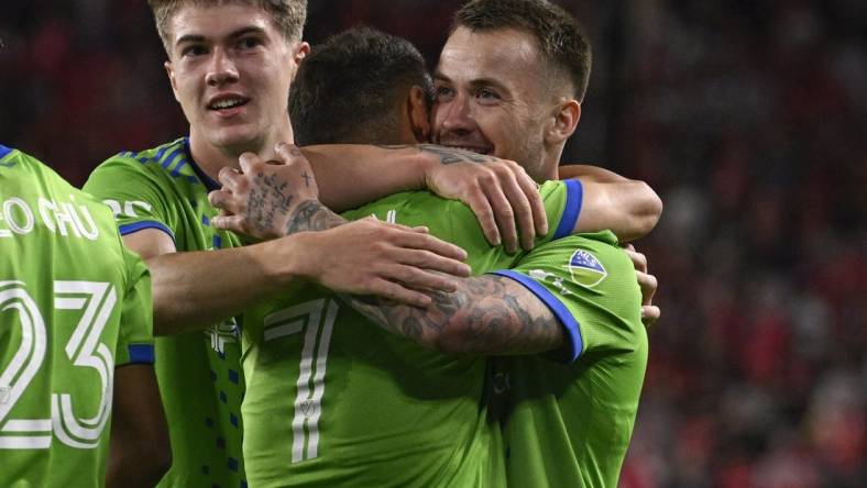 Oct 21, 2023; St. Louis, Missouri, USA; Seattle Sounders midfielder Cristian Roldan (7) congratulates Seattle Sounders midfielder Albert Rusnak (11) after Rusnak scored a goal against St. Louis City in the first half at CITYPARK. Mandatory Credit: Joe Puetz-USA TODAY Sports