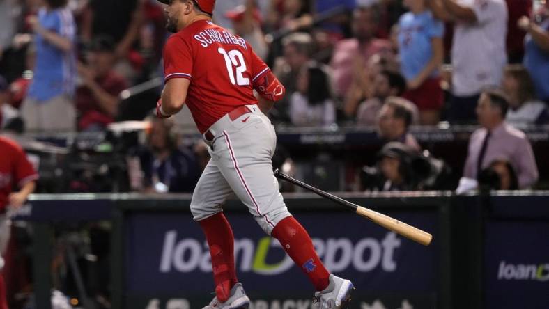 Oct 21, 2023; Phoenix, Arizona, USA; Philadelphia Phillies left fielder Kyle Schwarber (12) hits a home run against the Arizona Diamondbacks in the sixth inning during game five of the NLCS for the 2023 MLB playoffs at Chase Field. Mandatory Credit: Joe Camporeale-USA TODAY Sports