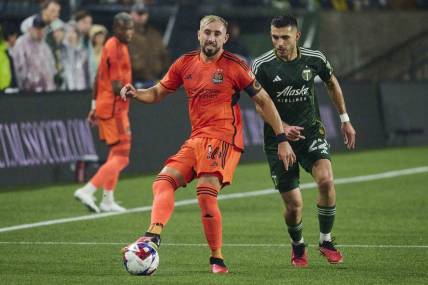 Oct 21, 2023; Portland, Oregon, USA; Houston Dynamo midfielder Hector Herrera (16) passes the ball against Portland Timbers midfielder Cristhian Paredes (22) during the first half at Providence Park. Mandatory Credit: Troy Wayrynen-USA TODAY Sports
