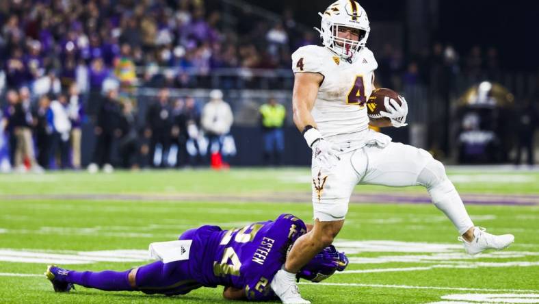 Oct 21, 2023; Seattle, Washington, USA; Arizona State Sun Devils running back Cameron Skattebo (4) breaks a table attempt by Washington Huskies safety Makell Esteen (24) while rushing during the fourth quarter at Alaska Airlines Field at Husky Stadium. Mandatory Credit: Joe Nicholson-USA TODAY Sports