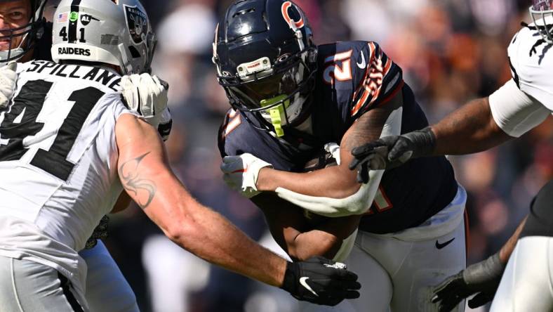 Oct 22, 2023; Chicago, Illinois, USA;  Chicago Bears running back D'Onta Foreman (21) fights through a tackle attempt from Las Vegas Raiders linebacker Robert Spillane (41) to score a touchdown in the second quarter at Soldier Field. Mandatory Credit: Jamie Sabau-USA TODAY Sports