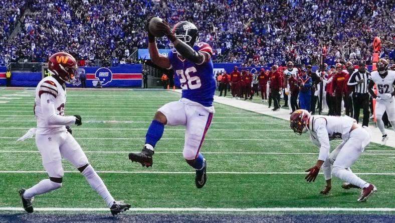 Oct 22, 2023; East Rutherford, New Jersey, USA; New York Giants running back Saquon Barkley (26) scores a  touchdown in the game against the Washington Commanders at MetLife Stadium. Mandatory Credit: Robert Deutsch-USA TODAY Sports