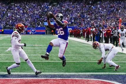 Oct 22, 2023; East Rutherford, New Jersey, USA; New York Giants running back Saquon Barkley (26) scores a  touchdown in the game against the Washington Commanders at MetLife Stadium. Mandatory Credit: Robert Deutsch-USA TODAY Sports