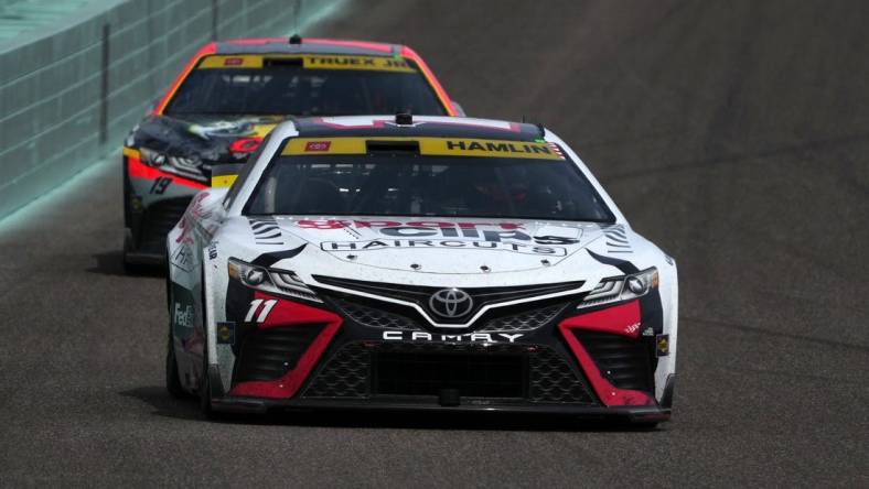 Oct 22, 2023; Homestead, Florida, USA; NASCAR Cup Series driver Denny Hamlin (11) leads NASCAR Cup Series driver Martin Truex Jr (19) during the 4EVER 400 presented by Mobil 1 at Homestead-Miami Speedway. Mandatory Credit: Jasen Vinlove-USA TODAY Sports