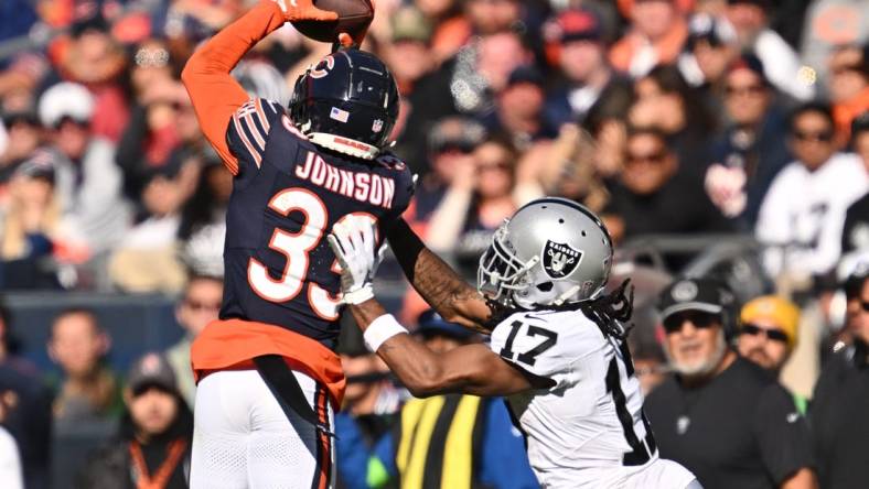 Oct 22, 2023; Chicago, Illinois, USA;  Chicago Bears defensive back Jaylon Johnson (33) steps in front of Las Vegas Raiders wide receiver Davante Adams (17) to intercept a pass before returning the ball for a touchdown in the fourth quarter at Soldier Field. Mandatory Credit: Jamie Sabau-USA TODAY Sports