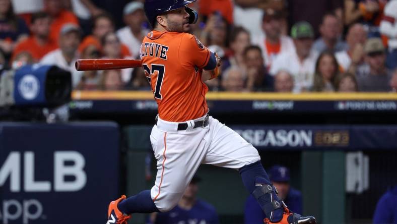 Oct 22, 2023; Houston, Texas, USA; Houston Astros second baseman Jose Altuve (27) hits a single against the Texas Rangers in the first inning during game six of the ALCS for the 2023 MLB playoffs at Minute Maid Park. Mandatory Credit: Troy Taormina-USA TODAY Sports