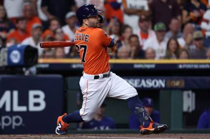 Oct 22, 2023; Houston, Texas, USA; Houston Astros second baseman Jose Altuve (27) hits a single against the Texas Rangers in the first inning during game six of the ALCS for the 2023 MLB playoffs at Minute Maid Park. Mandatory Credit: Troy Taormina-USA TODAY Sports