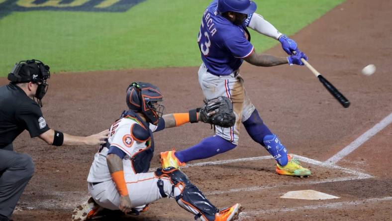 Oct 23, 2023; Houston, Texas, USA; Texas Rangers right fielder Adolis Garcia (53) hits a home run during the third inning of game seven in the ALCS against the Houston Astros for the 2023 MLB playoffs at Minute Maid Park. Mandatory Credit: Erik Williams-USA TODAY Sports