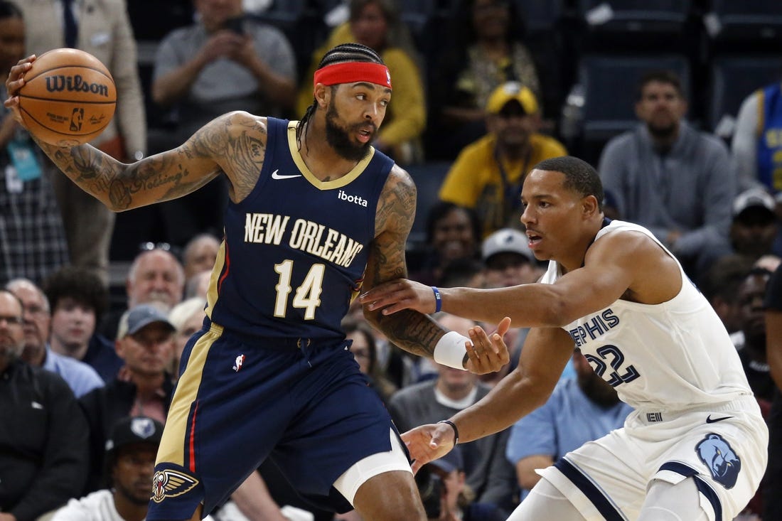 Oct 25, 2023; Memphis, Tennessee, USA; New Orleans Pelicans forward Brandon Ingram (14) catches a pass as Memphis Grizzlies guard Desmond Bane (22) defends during the first half at FedExForum. Mandatory Credit: Petre Thomas-USA TODAY Sports