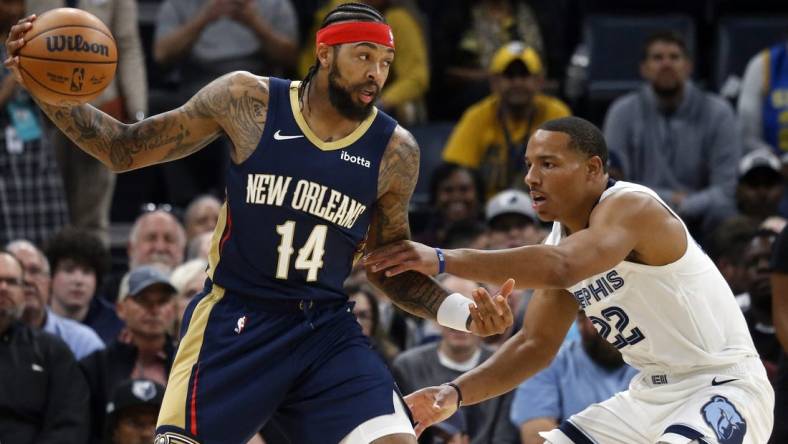 Oct 25, 2023; Memphis, Tennessee, USA; New Orleans Pelicans forward Brandon Ingram (14) catches a pass as Memphis Grizzlies guard Desmond Bane (22) defends during the first half at FedExForum. Mandatory Credit: Petre Thomas-USA TODAY Sports