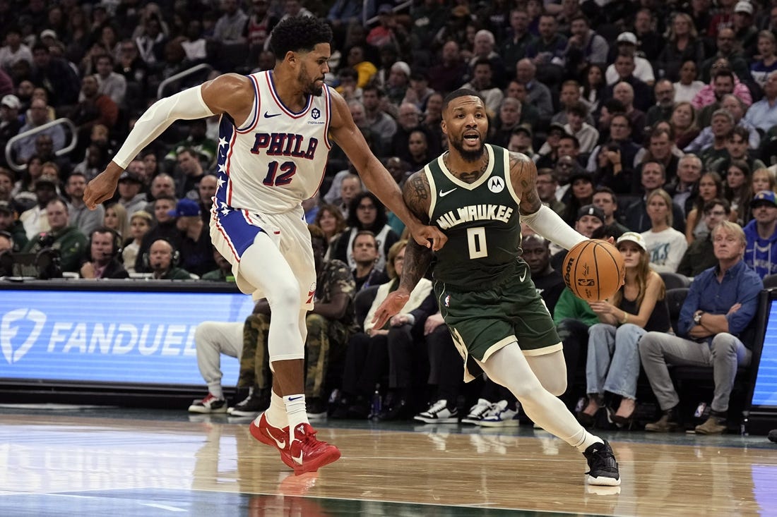 Oct 26, 2023; Milwaukee, Wisconsin, USA;  Milwaukee Bucks guard Damian Lillard (0) drives for the basket around Philadelphia 76ers forward Tobias Harris (12) during the second quarter at Fiserv Forum. Mandatory Credit: Jeff Hanisch-USA TODAY Sports