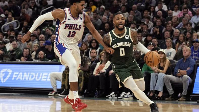 Oct 26, 2023; Milwaukee, Wisconsin, USA;  Milwaukee Bucks guard Damian Lillard (0) drives for the basket around Philadelphia 76ers forward Tobias Harris (12) during the second quarter at Fiserv Forum. Mandatory Credit: Jeff Hanisch-USA TODAY Sports