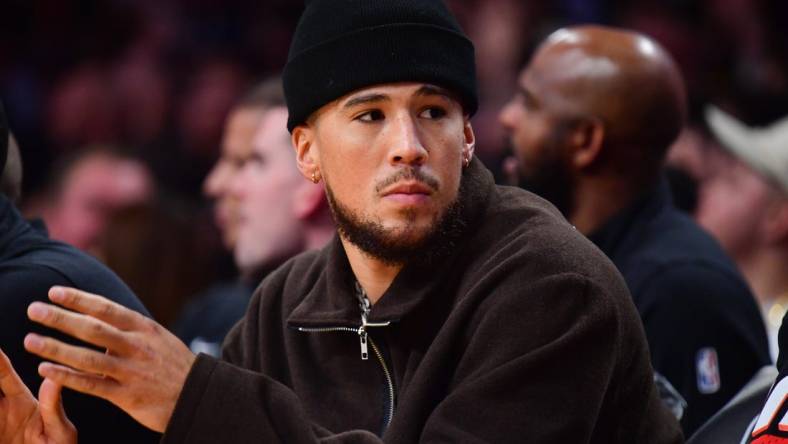 Oct 26, 2023; Los Angeles, California, USA; Phoenix Suns guard Devin Booker (1) watches game action against the Los Angeles Lakers during the first half at Crypto.com Arena. Mandatory Credit: Gary A. Vasquez-USA TODAY Sports