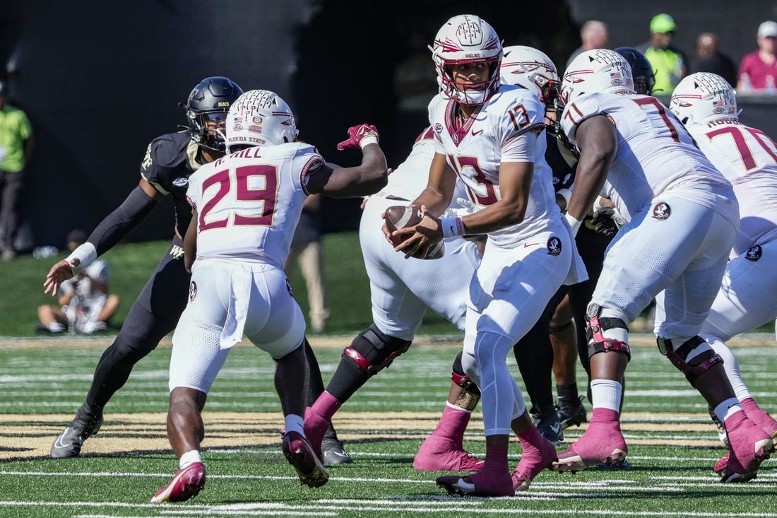 Oct 28, 2023; Winston-Salem, North Carolina, USA; Florida State Seminoles quarterback Jordan Travis (13) hands off the ball to running back Rodney Hill (29) during the first half against the Wake Forest Demon Deacons at Allegacy Federal Credit Union Stadium. Mandatory Credit: Jim Dedmon-USA TODAY Sports