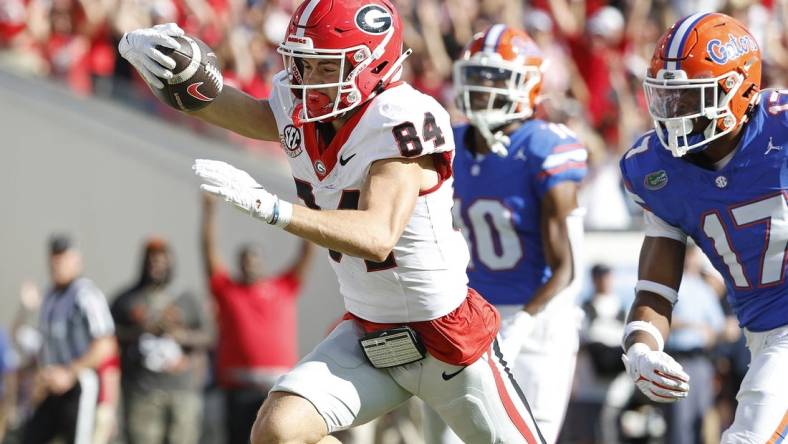 Oct 28, 2023; Jacksonville, Florida, USA; Georgia Bulldogs wide receiver Ladd McConkey (84) stretches for a touchdown past Florida Gators linebacker Scooby Williams (17) in the first half at EverBank Stadium. Mandatory Credit: Jeff Swinger-USA TODAY Sports