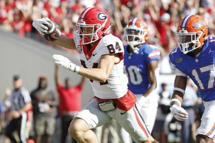 Oct 28, 2023; Jacksonville, Florida, USA; Georgia Bulldogs wide receiver Ladd McConkey (84) stretches for a touchdown past Florida Gators linebacker Scooby Williams (17) in the first half at EverBank Stadium. Mandatory Credit: Jeff Swinger-USA TODAY Sports