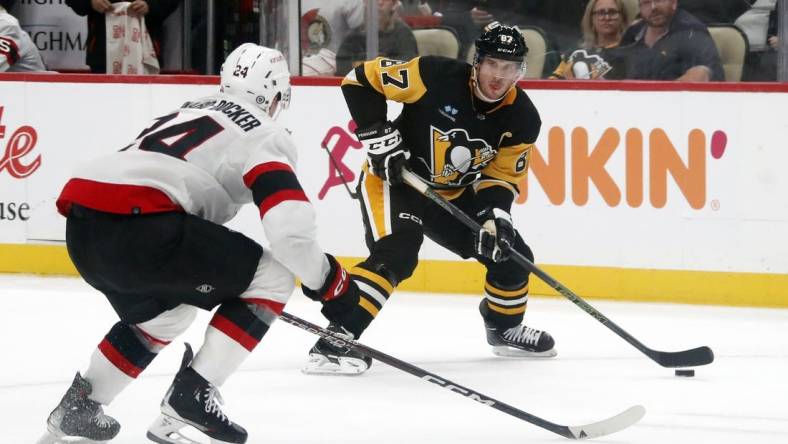 Oct 28, 2023; Pittsburgh, Pennsylvania, USA; Pittsburgh Penguins center Sidney Crosby (87) carries the puck as Ottawa Senators defenseman Jacob Bernard-Docker (24) defends during the first period at PPG Paints Arena. Mandatory Credit: Charles LeClaire-USA TODAY Sports