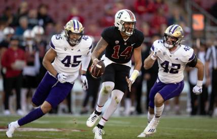 Oct 28, 2023; Stanford, California, USA; Stanford Cardinal quarterback Ashton Daniels (14) scrambles away from defensive pressure by Washington Huskies edge rusher Maurice Heims (45) and linebacker Carson Bruener (42) during the first quarter at Stanford Stadium. Mandatory Credit: D. Ross Cameron-USA TODAY Sports