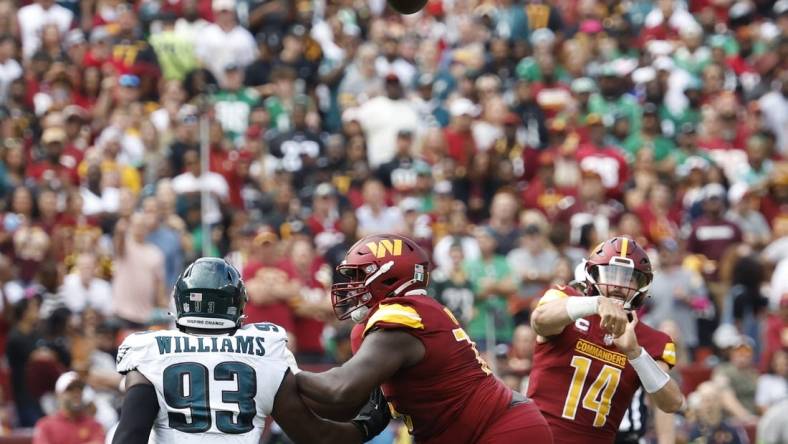 Washington Commanders quarterback Sam Howell (14) throws a touchdown pass as Philadelphia Eagles defensive tackle Milton Williams (93) defends during the first quarter at FedExField. Mandatory Credit: Geoff Burke-USA TODAY Sports