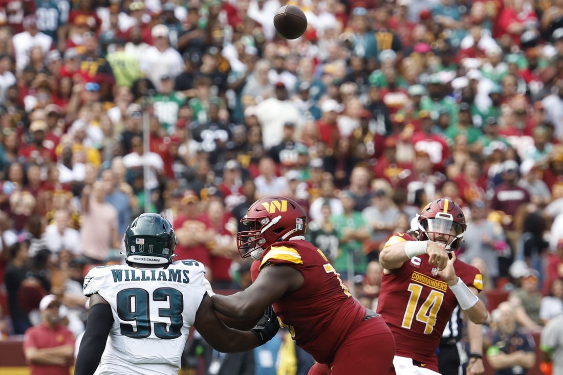 Washington Commanders quarterback Sam Howell (14) throws a touchdown pass as Philadelphia Eagles defensive tackle Milton Williams (93) defends during the first quarter at FedExField. Mandatory Credit: Geoff Burke-USA TODAY Sports