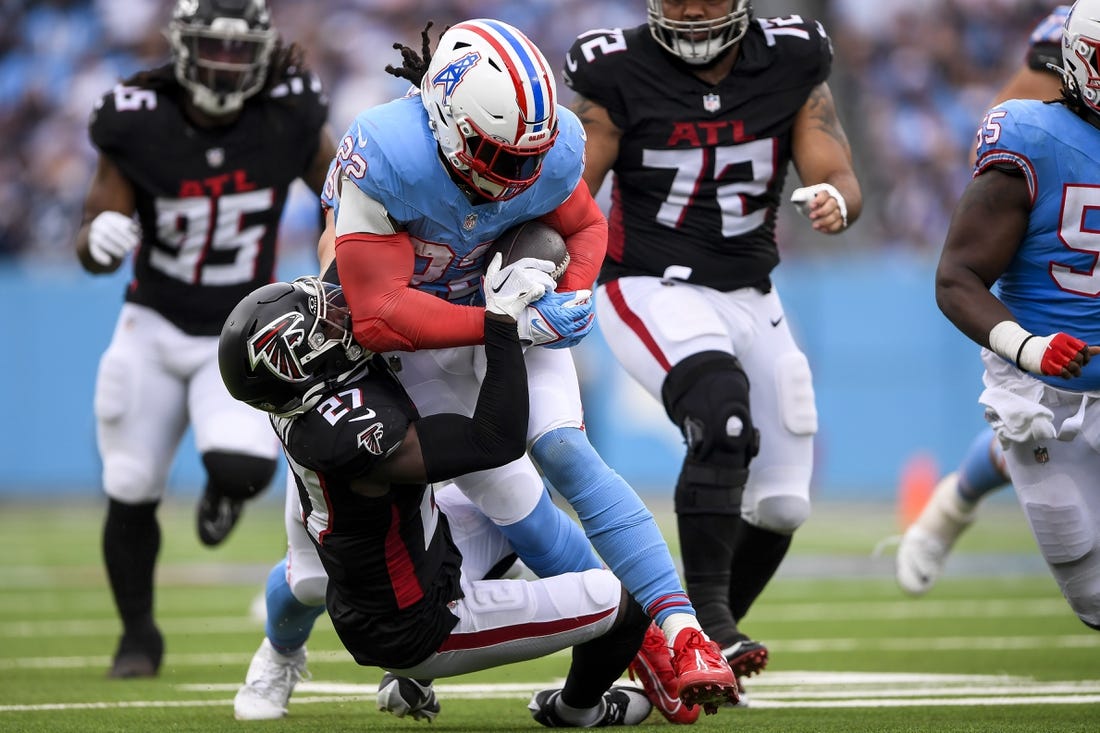 Oct 29, 2023; Nashville, Tennessee, USA;  Tennessee Titans running back Derrick Henry (22) runs as Atlanta Falcons safety Richie Grant (27) gets dragged during the first half at Nissan Stadium. Mandatory Credit: Steve Roberts-USA TODAY Sports