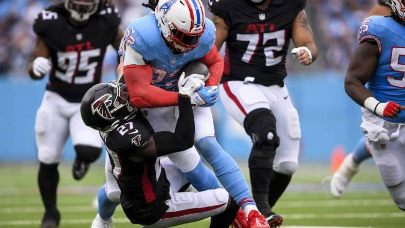 Oct 29, 2023; Nashville, Tennessee, USA;  Tennessee Titans running back Derrick Henry (22) runs as Atlanta Falcons safety Richie Grant (27) gets dragged during the first half at Nissan Stadium. Mandatory Credit: Steve Roberts-USA TODAY Sports